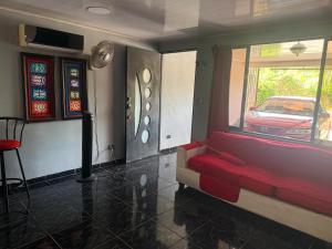 a living room with a red couch and a car outside at La comodidad a su alcance in La Cuesta +1 photo