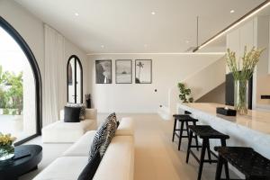 a living room with a white couch and a counter at Casa Infinity Villa 2 - Oasis 3BR & Ocean View by BaliSuperHost in Mengwi