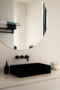 a bathroom with a mirror and a black sink at Casa Infinity Villa 2 - Oasis 3BR & Ocean View by BaliSuperHost in Mengwi +31 photos