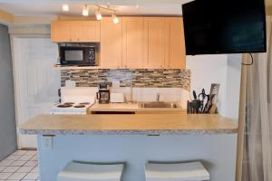 a kitchen with a counter with a sink and a microwave at Shortboard in Holmes Beach