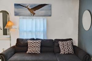 a couch in a living room with a bird flying overhead at Shortboard in Holmes Beach