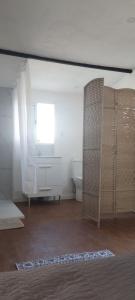 a room with a bathroom with a window and a sink at L'évidence in Alcantarilha