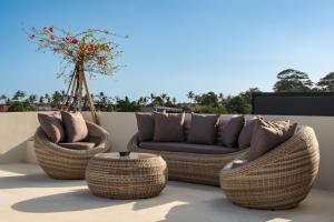 three wicker chairs and a couch on a patio at Casa Infinity Villa 2 - Oasis 3BR & Ocean View by BaliSuperHost in Mengwi