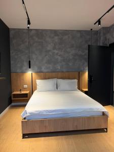 a bedroom with a large bed with white sheets at NOOR Boutique Hotel in Koplik