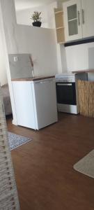 a kitchen with a stove and a white refrigerator at L'évidence in Alcantarilha