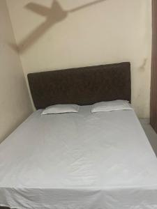 a bed with two pillows and a shadow on the wall at Skyline hotel in Barnāla