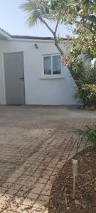 a white building with a door and a window at L'évidence in Alcantarilha
