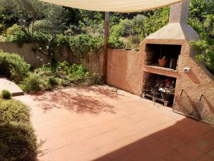 a patio with a pizza oven in a garden at Villa Paradiso holidays in Costa Paradiso +2 photos