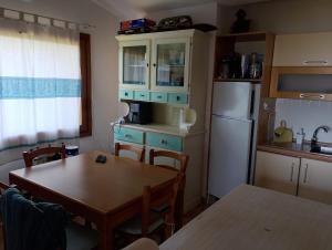 a kitchen with a table and a white refrigerator at Villa Paradiso holidays in Costa Paradiso