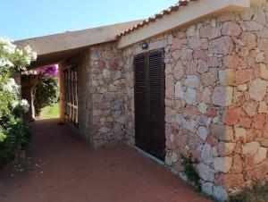 a brick wall with a gate and a door at Villa Paradiso holidays in Costa Paradiso