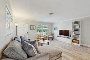 a living room with a couch and a tv at Mint Green Getaway in Holmes Beach