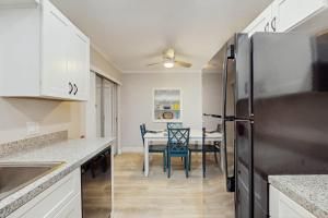 a kitchen with a refrigerator and a table with chairs at Mint Green Getaway in Holmes Beach +14 photos