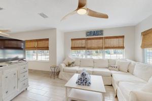 a living room with a white couch and a table at King Crab in Holmes Beach