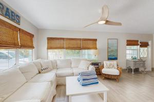 a living room with a white couch and a ceiling fan at King Crab in Holmes Beach