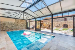 an indoor swimming pool with a glass ceiling at L'Apothicaire 2 Chambres - Piscine in Montaigu-Vendée