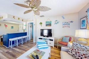 a living room with a couch and a flat screen tv at The Villas, Condo 1A in Holmes Beach +25 photos