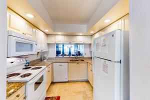 a kitchen with white appliances and white cabinets at Shorewalk 103 in Bradenton