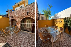a patio with a table and chairs and a brick building at Ayvalık 1892 Konukevi in Ayvalık