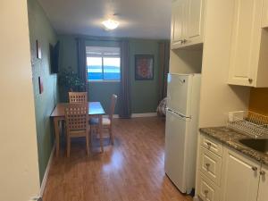a kitchen and dining room with a table and a refrigerator at Bayside Inn in Alert Bay