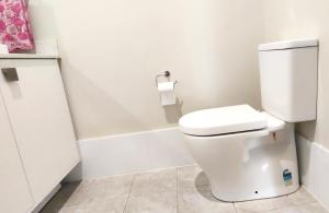 a bathroom with a toilet and a roll of toilet paper at The Fifth Season in Unanderra +2 photos
