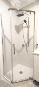 a shower with a glass enclosure in a bathroom at The Fifth Season in Unanderra