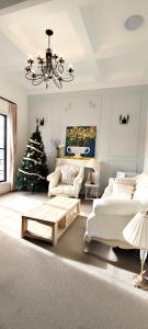 a living room with a christmas tree and a chandelier at The Fifth Season in Unanderra
