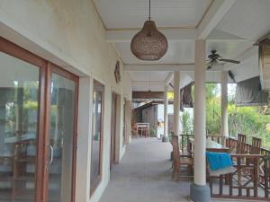 a porch of a house with a table and chairs at Nyoman Guest House 1 in Ambat