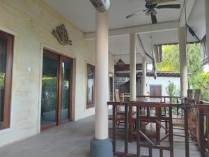 a porch of a house with a table and chairs at Nyoman Guest House 1 in Ambat