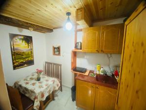 a small room with a table and a kitchen with a sink at Guest House Castle in Koman