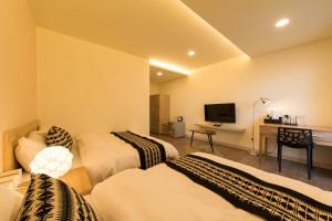 台南的住宿－築窩，客房设有三张床和一张书桌及一台电视