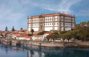 a large building on the side of a river at Studio Praia & Sol De Verão in Vila do Conde