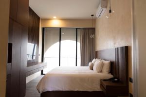 a bedroom with a large bed and a large window at Moreira Hotel Boutique in Mérida
