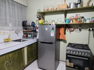 a kitchen with a refrigerator and a stove at Victorious place in Kitale