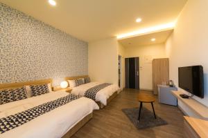 台南的住宿－築窩，酒店客房设有两张床和一台平面电视。