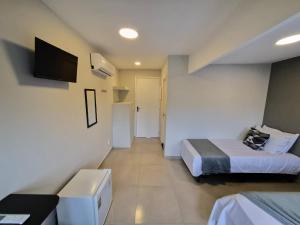 a hotel room with two beds and a tv at CaisSuites in Cabo Frio