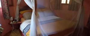 a small bed in a room with a curtain at Villa Les Flamboyants in Somone +11 photos