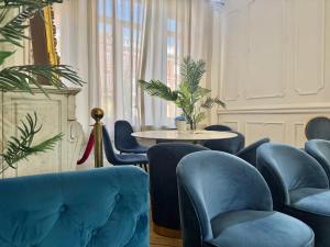 a living room with blue chairs and a table at Grande Chambre lumineuse Proche Gare et centre ville , métro , Charmante vieille maison Bourgeoise in Tourcoing +2 photos
