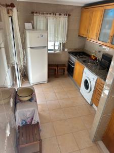 a kitchen with a refrigerator and a washing machine at Casa Prédio triplex - Faneca Apartamentos in Nazaré +7 photos