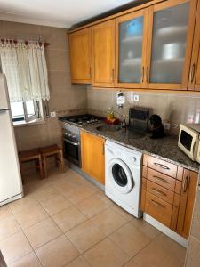 a kitchen with a washing machine in a kitchen at Casa Prédio triplex - Faneca Apartamentos in Nazaré