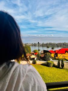 a woman looking out of a window at a house at Mona Rusizi in Cyangugu +11 photos