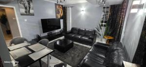 a living room with a black leather couch and a table at The Blair Luxury in Paulo