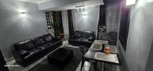 a living room with black leather furniture and a table at The Blair Luxury in Paulo