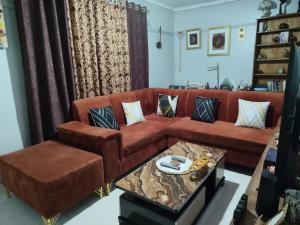 a living room with a brown couch and a table at Victorious place in Kitale