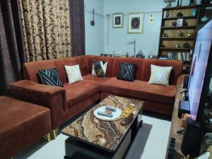 a living room with a brown couch and a table at Victorious place in Kitale
