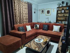 a living room with a brown couch and a table at Victorious place in Kitale