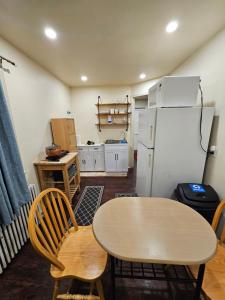 a kitchen with a table and a refrigerator at Cozy 111 in Elmont