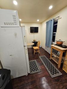 a kitchen with a white refrigerator and a table at Cozy 111 in Elmont