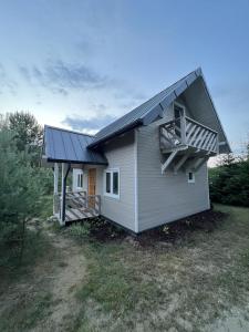 a small house with a porch and a balcony at Sosenkowe Zacisze in Ciche