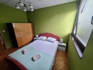 a small bedroom with a bed and a green wall at Villa Tira in Jajce