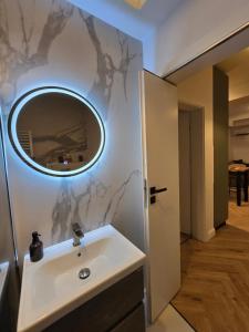 a bathroom with a sink and a mirror on the wall at Cozy Central Home & Free Private Parking in Craiova +49 photos